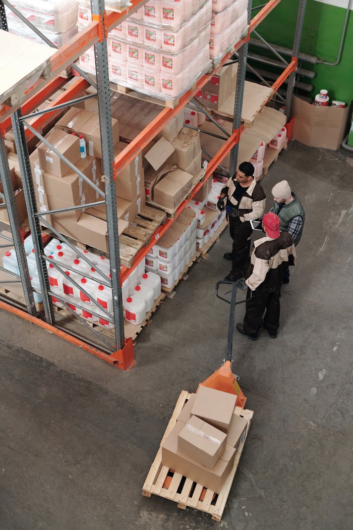 about-03 Three warehouse workers discussing inventory organization details.