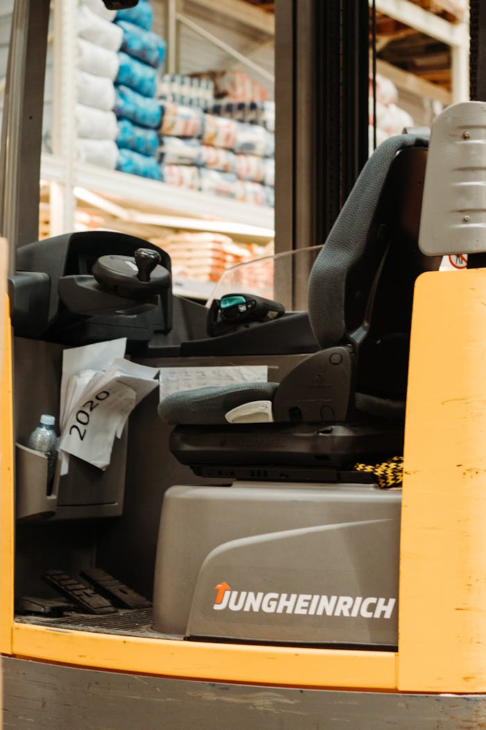 who-we-are-02 Interior of an empty forklift in a warehouse with stacks of products.