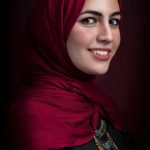 Stunning profile portrait of a woman wearing a red hijab, showcasing beauty and elegance.